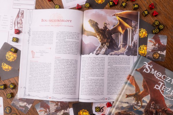 Zdjęcie akcesoriów i rozłożonego podręcznika do gry Smoczy Jeźdźcy